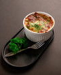 © suraded - spinach with cheese On a black plate.spinach with cheese On a black plate. Baked Spinach with Cheese