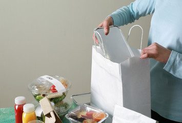 Worker of food delivery service packing order for customer