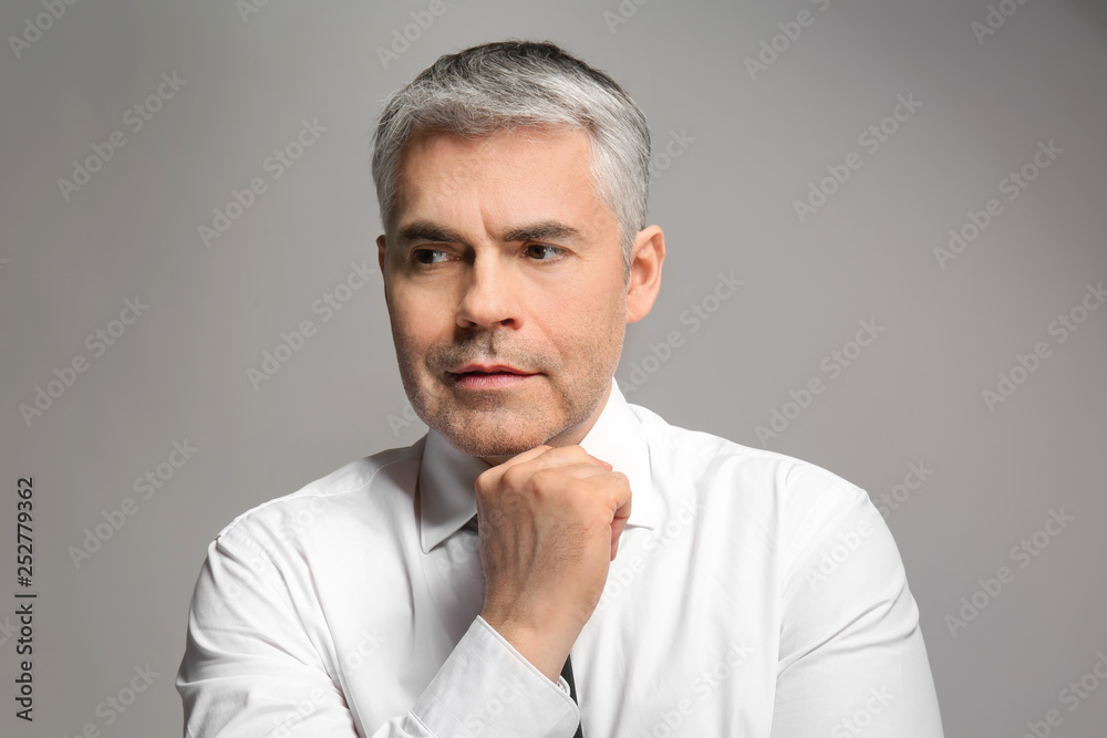 Handsome mature businessman on grey background