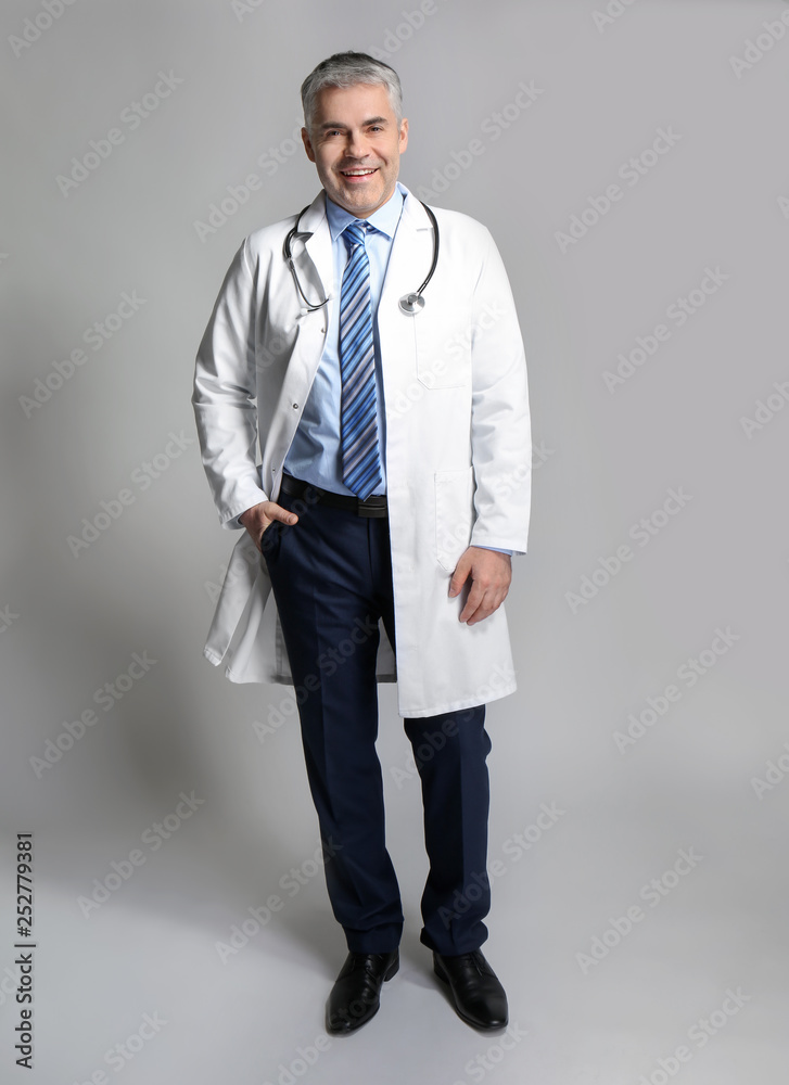 Mature doctor on grey background