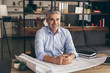 © Pixel-Shot - Mature architect working with drawings in office