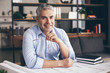 © Pixel-Shot - Mature architect working with drawings in office