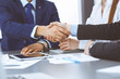 © rogerphoto - Business people shaking hands, finishing up a papers signing. Meeting, contract and lawyer consulting concept