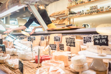 Shop Clerk Woman Sorting Cheese In The Supermarket Display