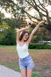 © sosiukin - Young girl has a great mood. Beautiful woman is listening to her favourite song in headphones on mobile phone. Smiling and laughing lady is dancing in the park