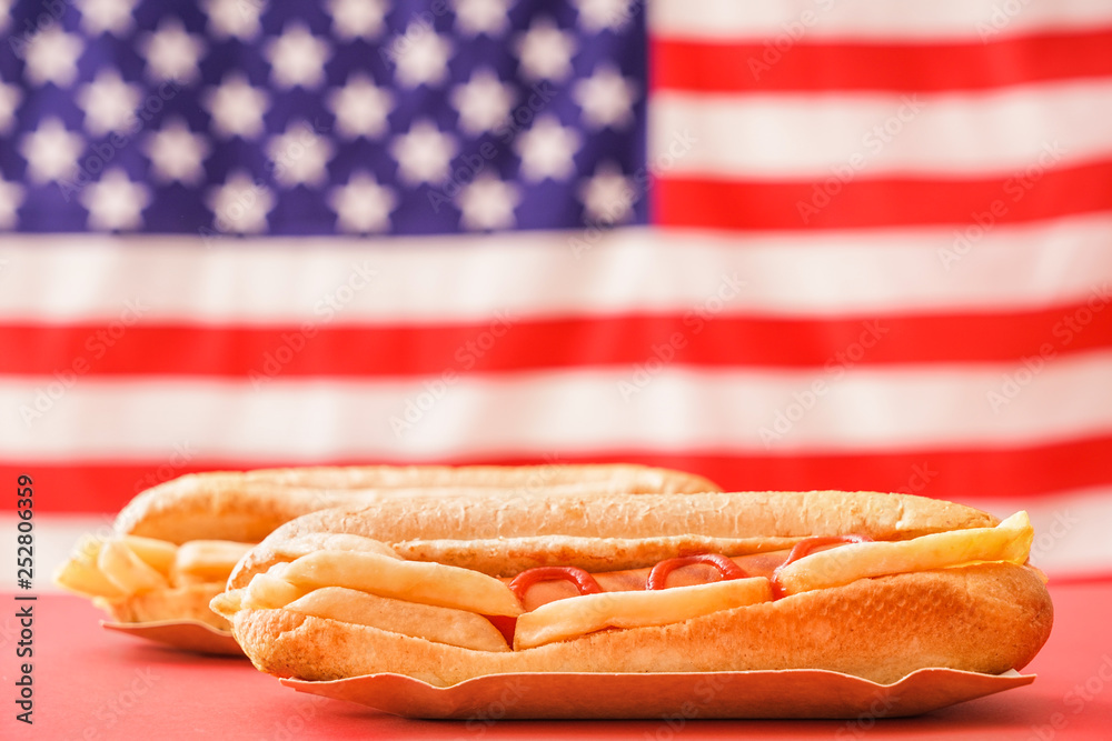 Tasty hot dogs on color table