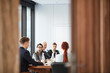 © Seventyfour - View of business meeting in conference room through open door, copy space