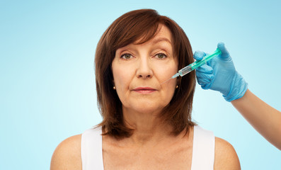 Sticker - beauty, plastic surgery and cosmetology concept - senior woman and surgeon hand with syringe over blue background