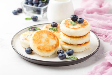 Wall Mural - Cheesecakes from cottage cheese, delicious Breakfast, traditional Russian sweet pancakes. With blueberry, mint and sauce