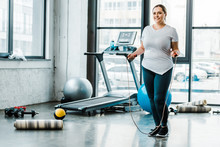 Cheerful Plus Size Woman Standing With Jumping Rope In Gym