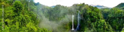 Fotomural Aerial over Sekumpul waterfall surrounded by dense rainforest and mountains shro