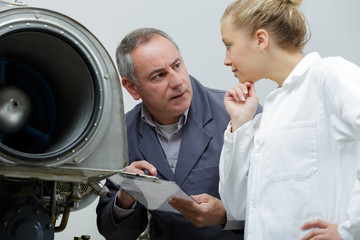 Wall Mural - male and female engineers repairing aircraft