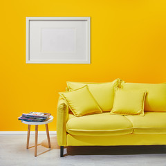 Wall Mural - coffee table standing near modern yellow sofa near white frame hanging on wall