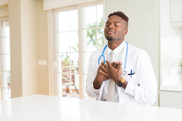 Sticker - African american doctor man at the clinic smiling with hands on chest with closed eyes and grateful gesture on face. Health concept.