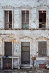 Wall Mural - Aged abandoned retro vintage grunge house facade with broken door and windows and weathered shutters