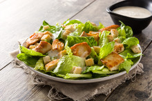 Caesar Salad With Lettuce,chicken And Croutons On Wooden Table.