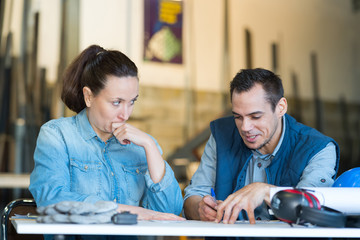 two factory workers with documents in hand