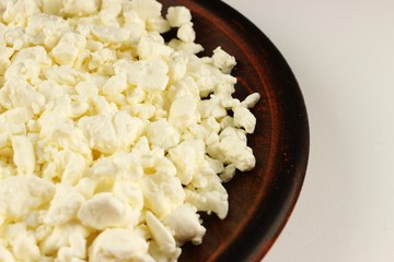 Poster - Homemade cheese in a plate on a white background