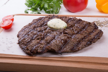 Prepared steak served with butter on board