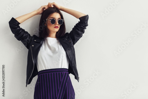Young beautiful woman in a black jacket and sunglasses Fotobehang