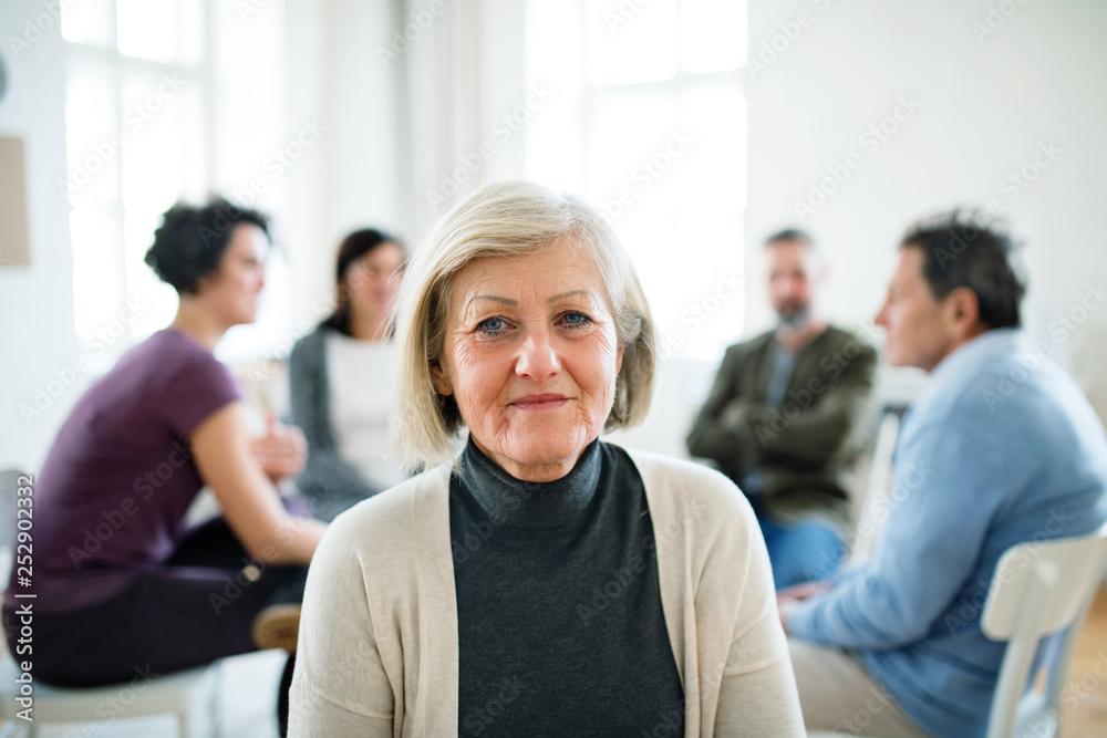 A portrait of senior depressed woman during group therapy. - obrazy, fototapety, plakaty 