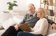 © Prostock-studio - Happy couple looking at photo album together