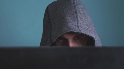 man hacker in the hood hacking network concept. unknown hacker criminal breaks into computer protection on the Internet passwords. male hacker penetrates into hack network lifestyle protection web
