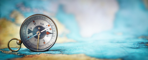 magnetic old compass on world map.travel, geography, navigation, tourism and exploration concept wid
