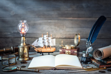 Wall Mural - Travel and nautical theme grunge background. Old book, compass, telescope, divider, coins, shell, map, hourglass, quill pen on wood desk. Columbus Day.