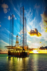 Wall Mural - Oil drilling rig in sunset time.