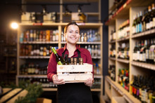 Image Of Happy Brunette Seller With Wooden Box With Wine In Store