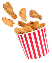 Perfect fried chicken pieces flying around in red white striped box