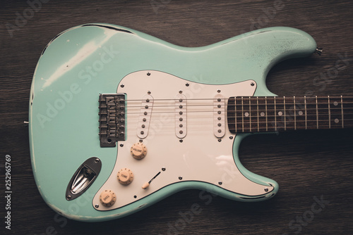 Fotomural Light blue electric guitar against brown wood background
