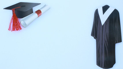 Black cap and gown with red tassel and diploma for graduation