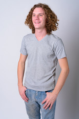 Wall Mural - Portrait of happy young handsome man with curly hair thinking