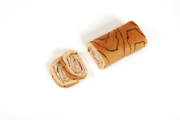 Wall Mural - Biscuit roll cut into pieces, on a white background.