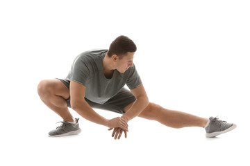 Sporty young man training against white background