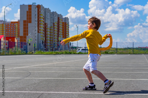 Fotografía the boy throws a boomerang into the blue sky