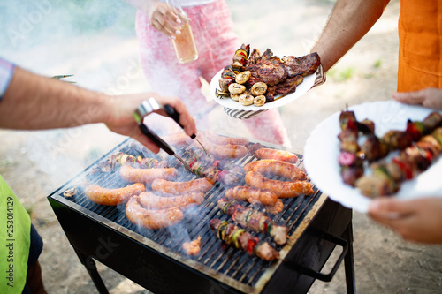 Fotografía Happy friends camping and having a barbecue in nature