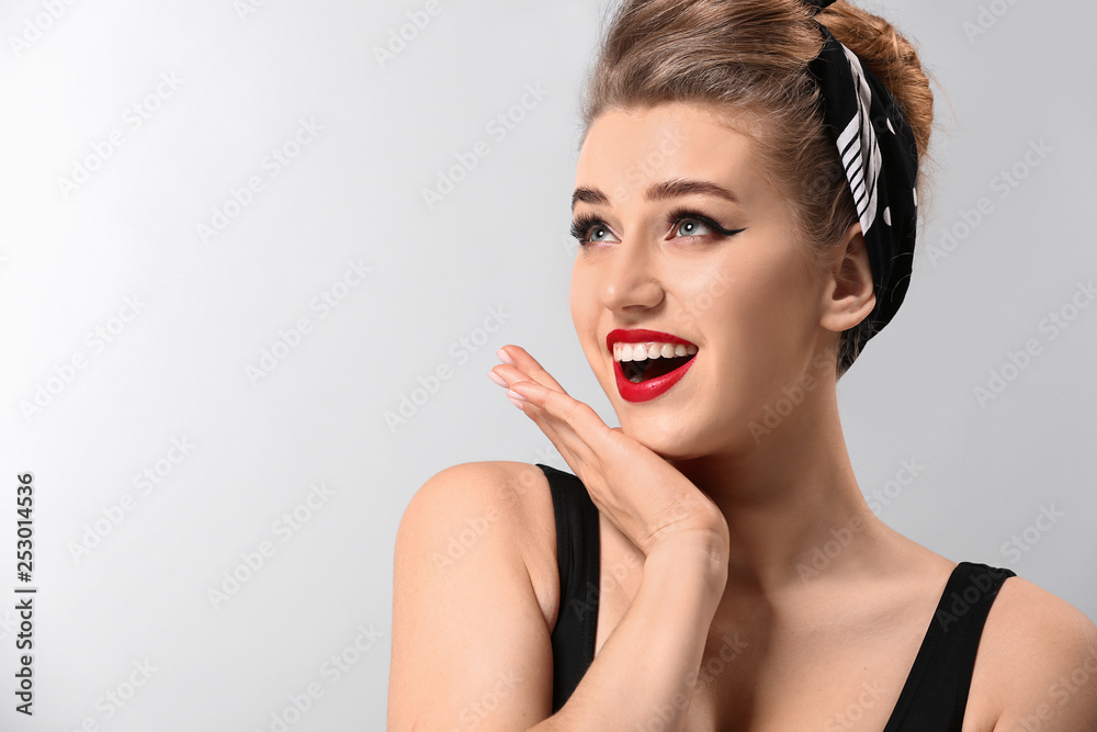 Beautiful pin-up woman on grey background