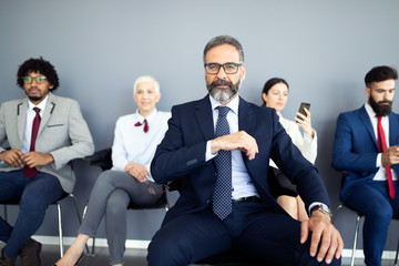 Wall Mural - Portrait of senior businessman as leader at modern bright office interior