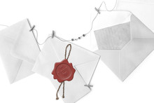 Post Envelopes And Vintage Blank Cards. Red Wax Seal With Word Love And Heart Shape. All Objects Are Hanging On A Rope Attached With Clothes Clothespins. Objects Are On White Background