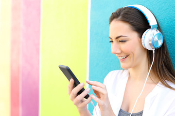 Wall Mural - Happy woman listens to music in a colorful street