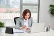 © makistock - Asian businesswoman or accountant working pointing graph discussion and analysis data charts and graphs and using a calculator to calculate numbers. Business finances and accounting concept