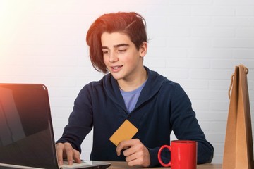 Sticker - young man with credit card and laptop buying online