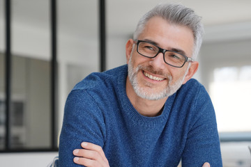 Wall Mural - Portrait of smiling man with grey hair and glasses