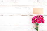 Fototapeta Lawenda - May mothers day concept photography - Beautiful carnations with template card isolated on a bright wooden table, copy space, flat lay, top view, mock up