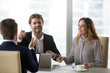 © fizkes - Cheerful colleagues laughing at joke at meeting having funny conversation