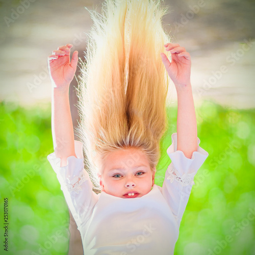Cheerful Young Girl With Long Blond Hair Hangs Upside Down