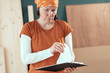 © Bits and Splits - Female carpenter reading DIY project notes